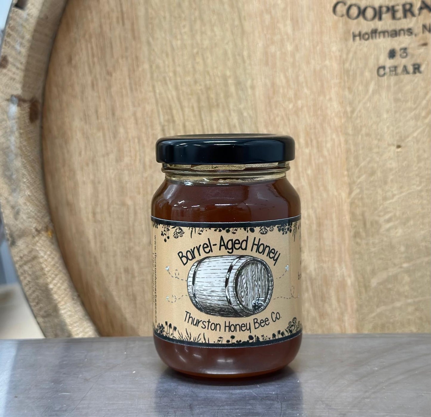 Jar of Barrel Aged Honey from Thurston Honey Bee Co on a wooden background