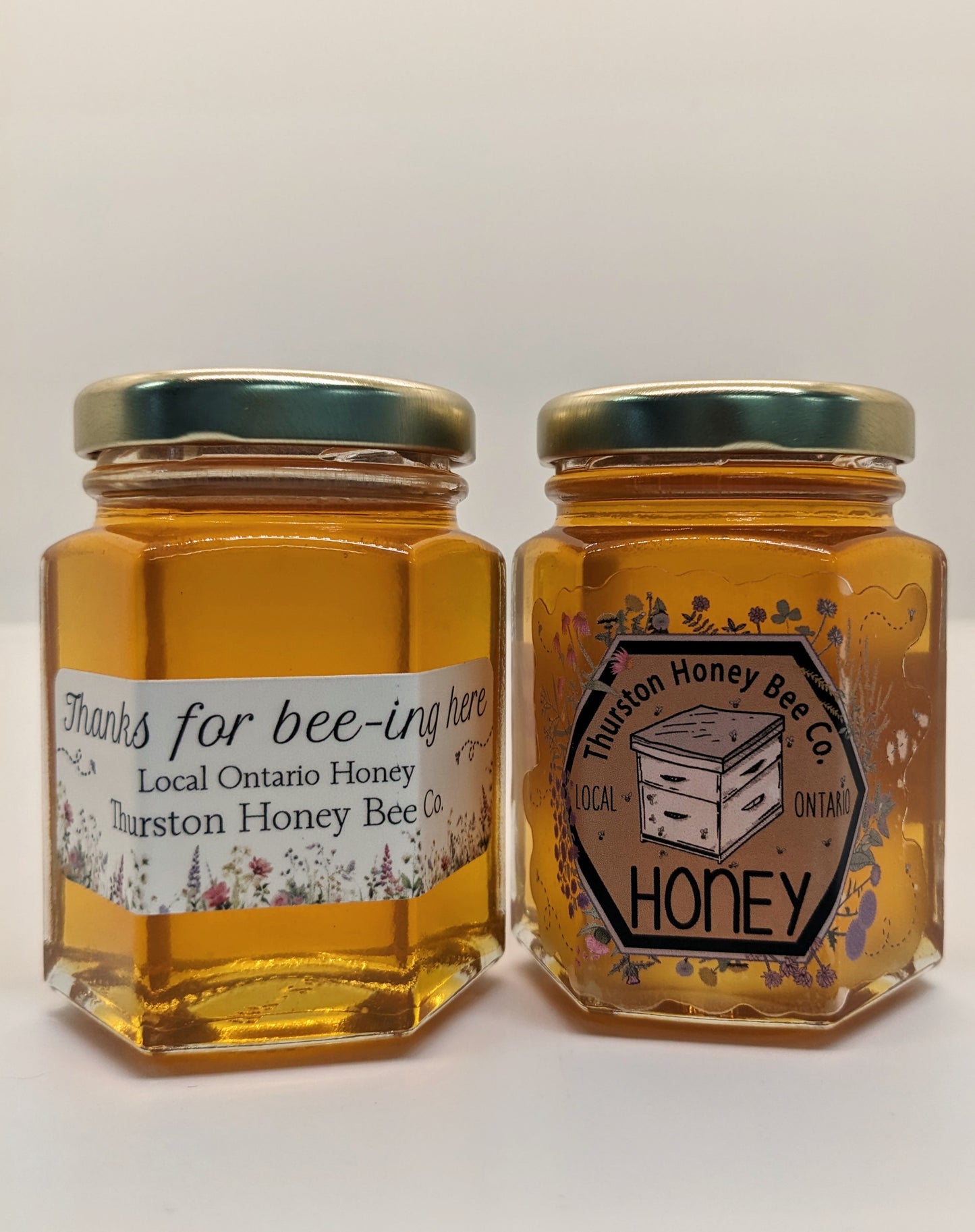 Two jars of honey from Thurston Honey Bee Co. on a white background